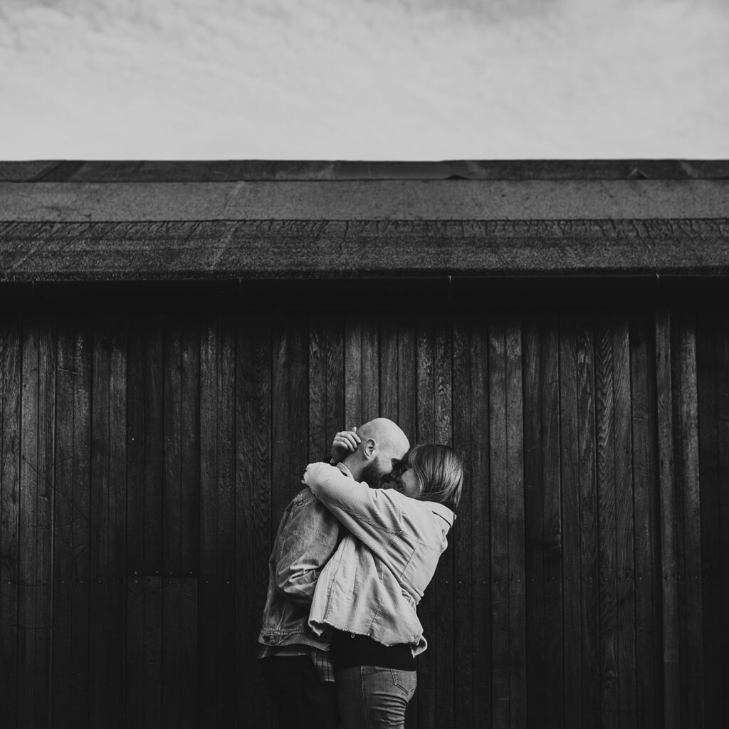 Big cuddle outside a shed at Norfolk Beach for an engagement shoot