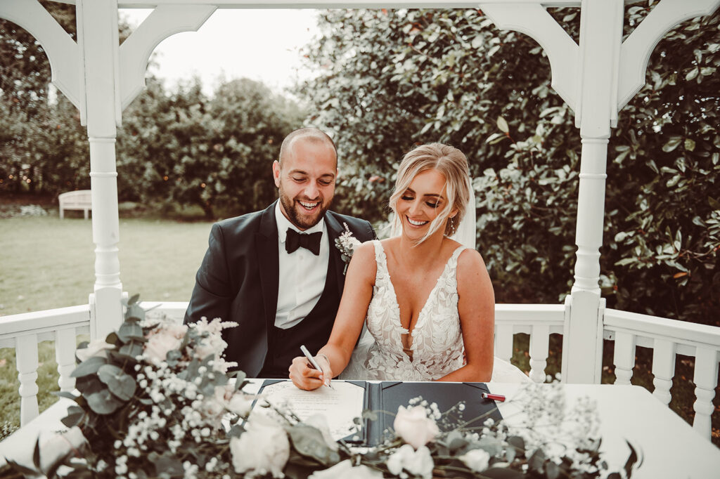 Old Kent Barn Autumn Wedding as the couple signs the register