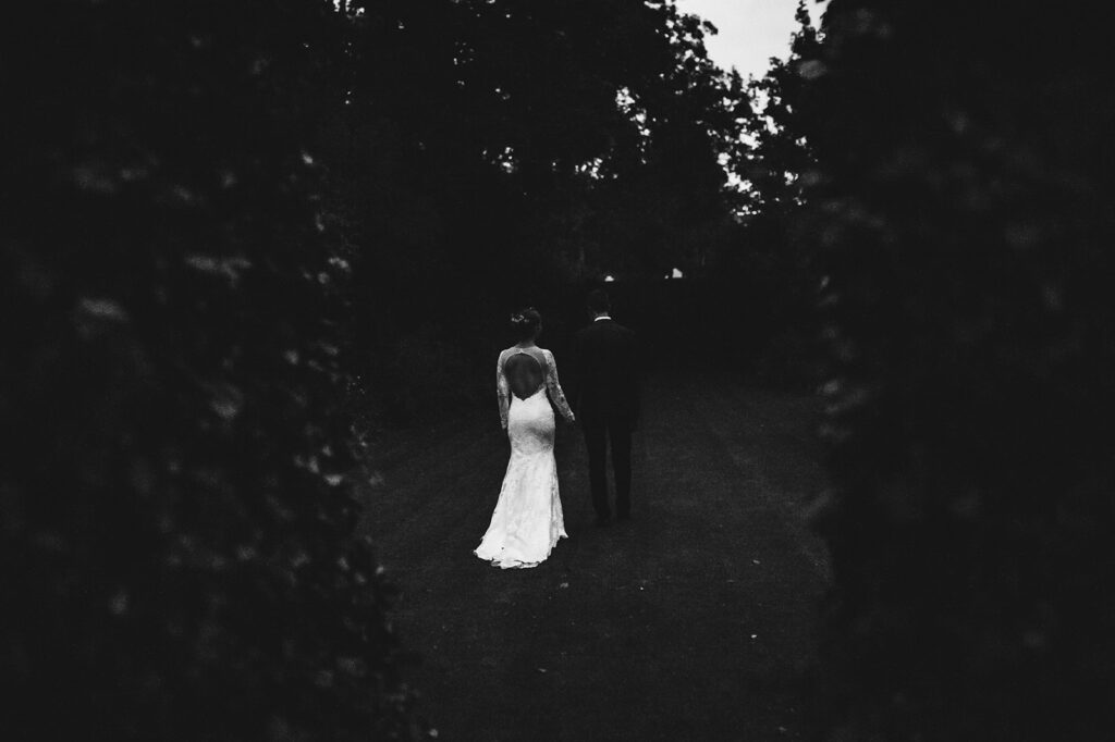 Newlywed couple walking through the mansion gardens of their luxury wedding in Dover, Kent.