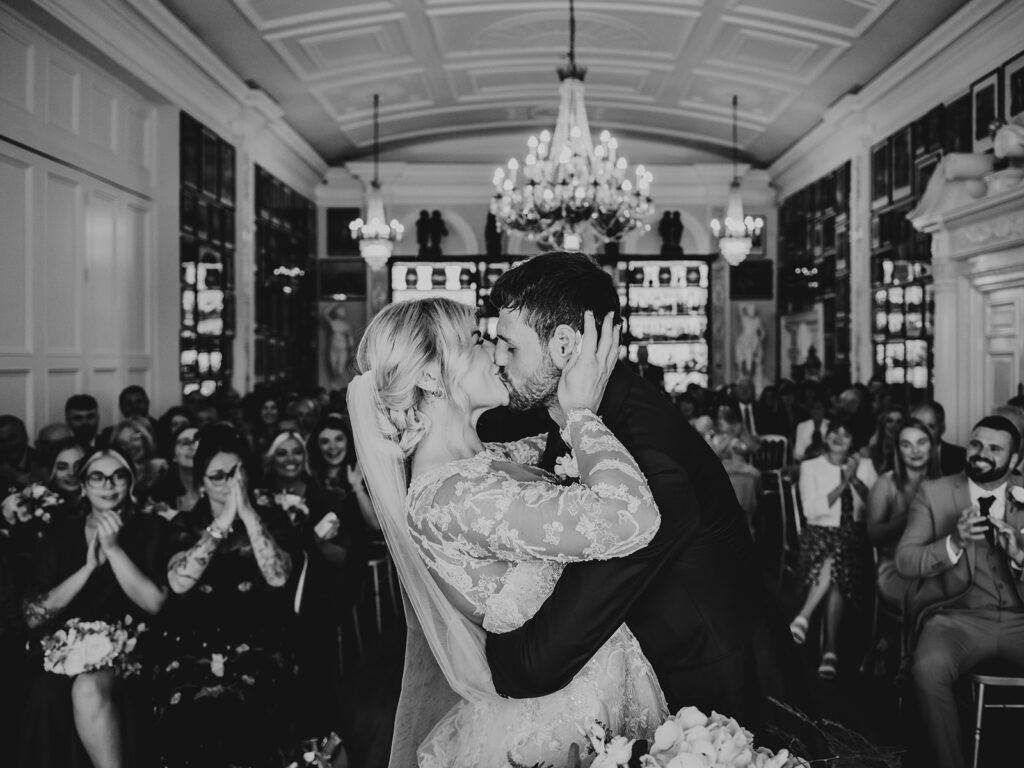 Newlywed couple having a first kiss on their wedding day