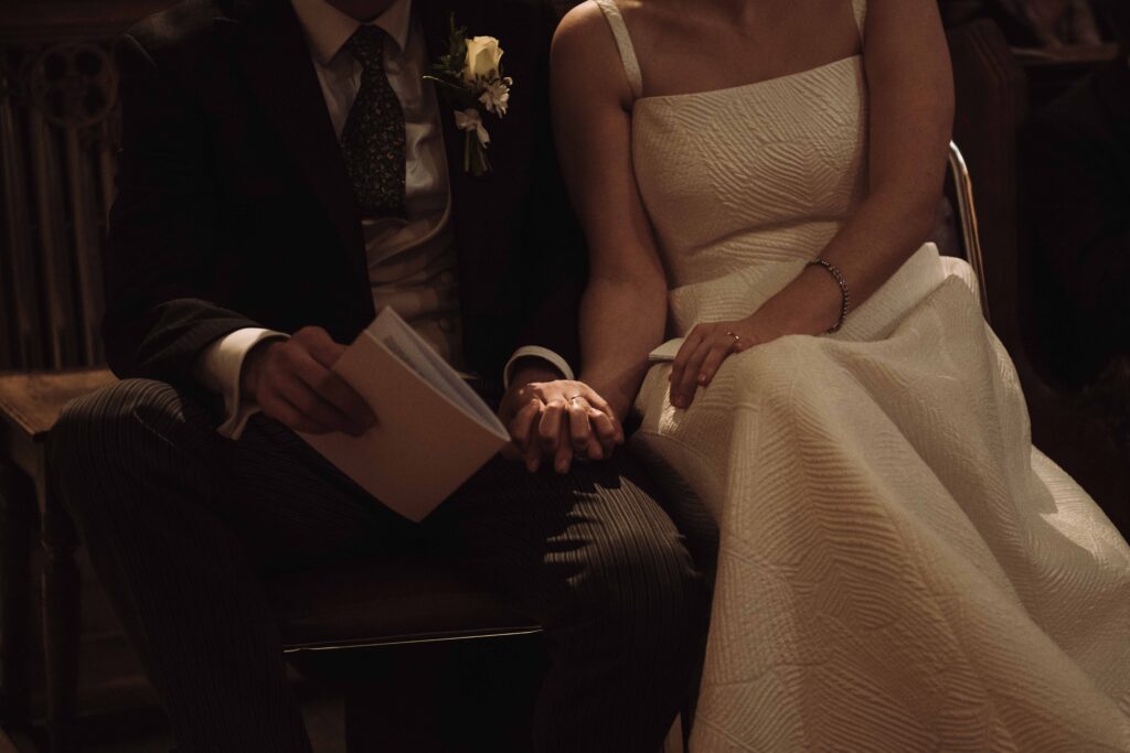 Bride and groom holding hands during ceremony at wedding