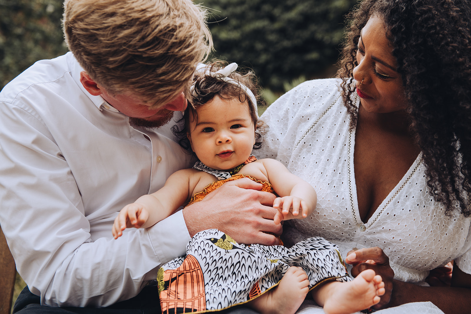 Family cuddling their daughter on a photo shoot at Westcott House in Cambridge