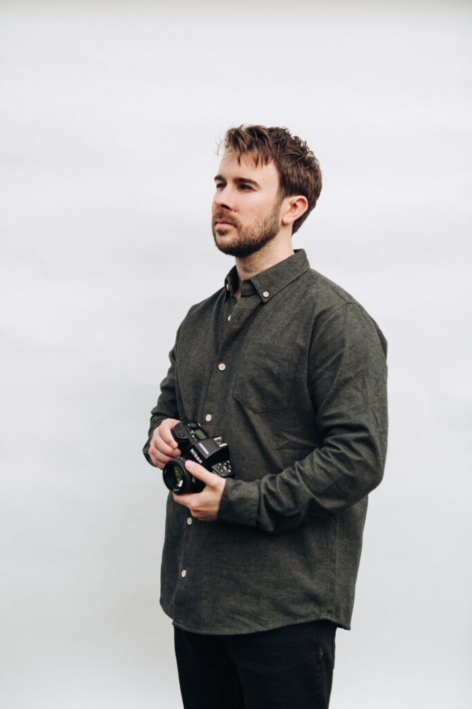 photograph of tom keenan in his studio holding an analogue film camera