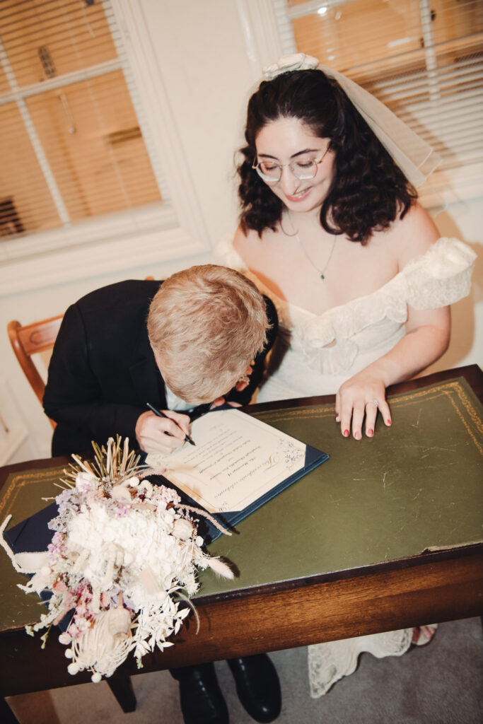 Bride and groom signing registers