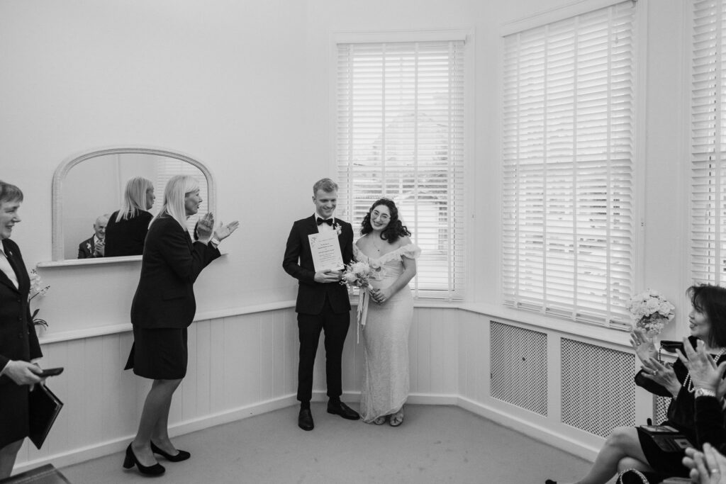Bride and groom celebrating with their wedding certificate