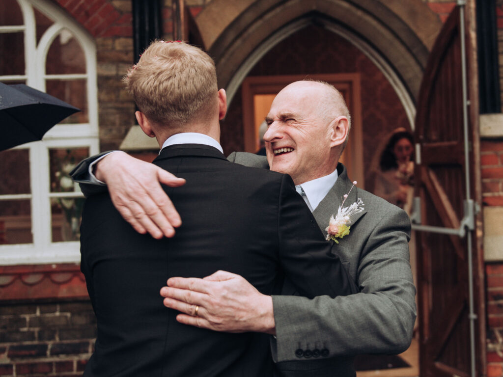Father of the bride hugging groom