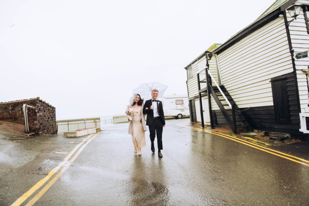 Bride and groom walking out of beach car park at Viking Bay in Broadstairs