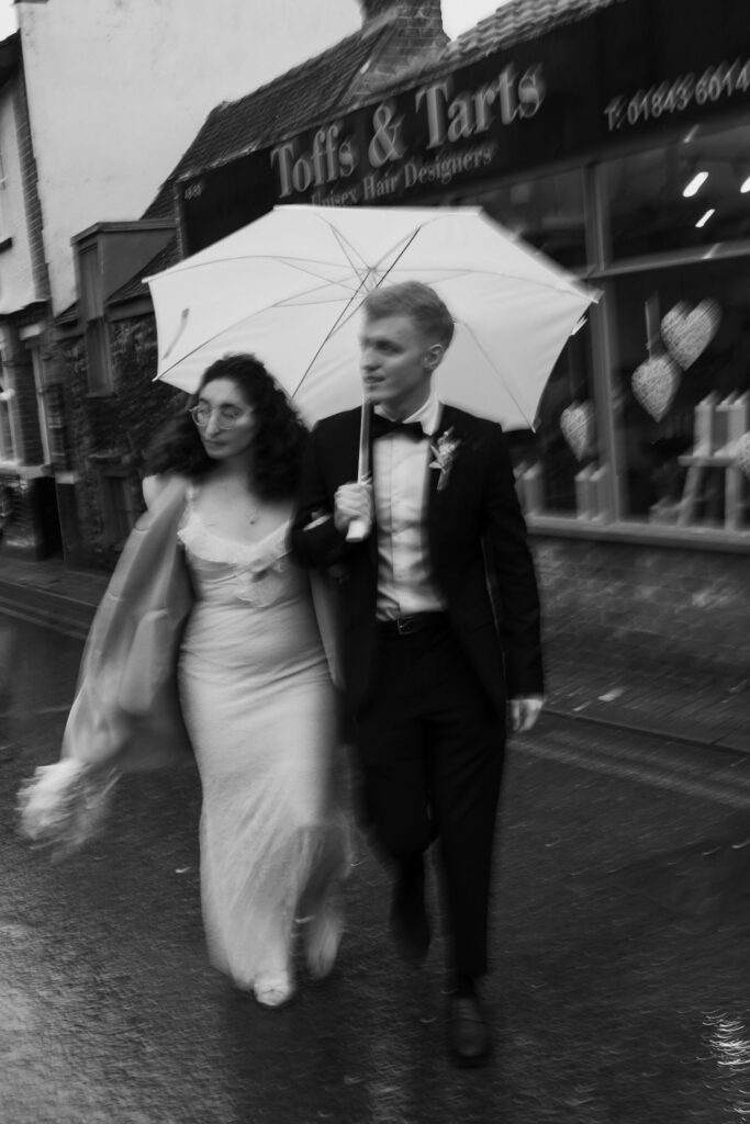 Bride and groom running through rain in Broadstairs