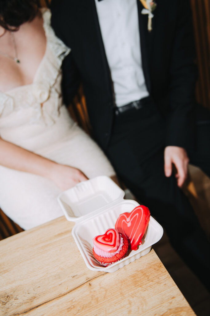 Bride and groom sat in a chair with Valentines cake in Giant Coffee in Broadstairs