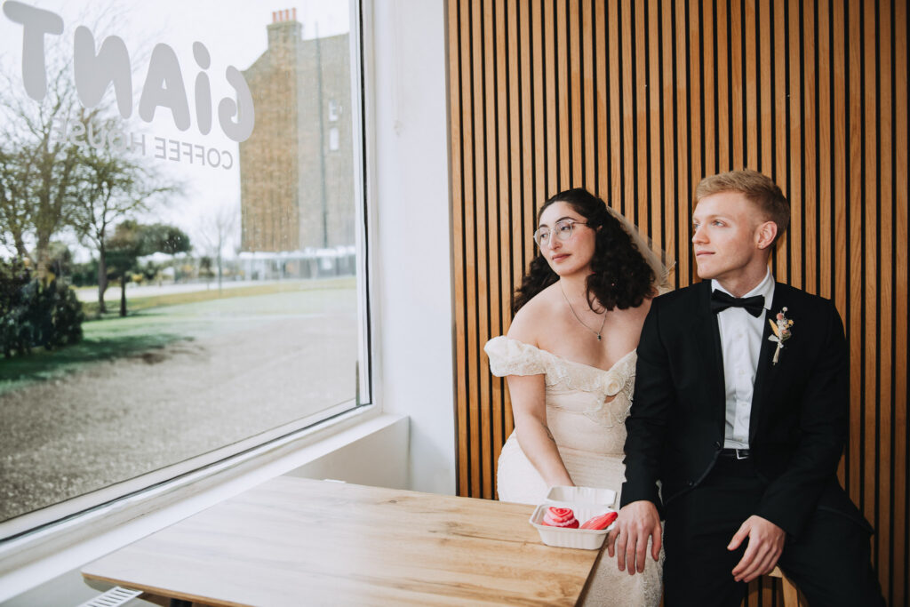 Bride and groom sat in a chair looking out of the window in Giant Coffee in Broadstairs