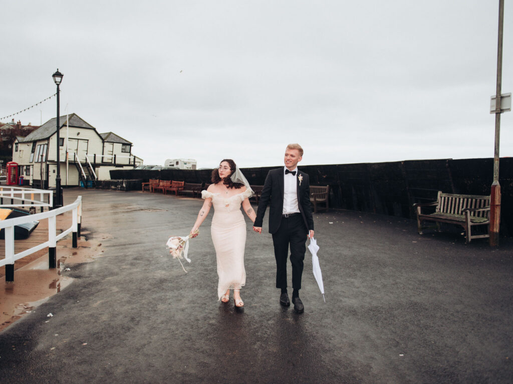 Bride and groom walking on the pier at Viking Bay in Broadstairs
