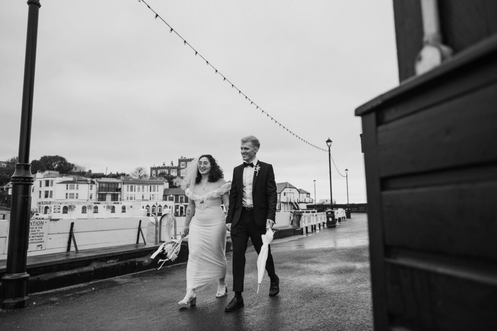 Bride and groom walking on the pier at Viking Bay in Broadstairs