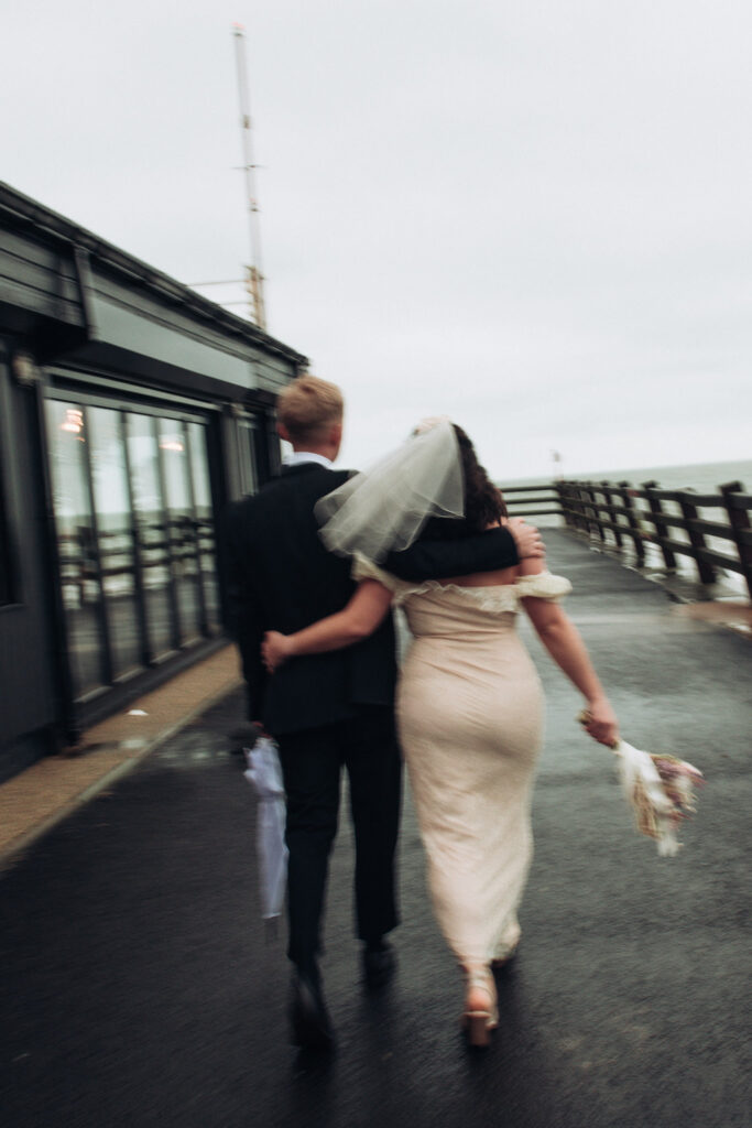 Bride and groom walking on the pier at Viking Bay in Broadstairs