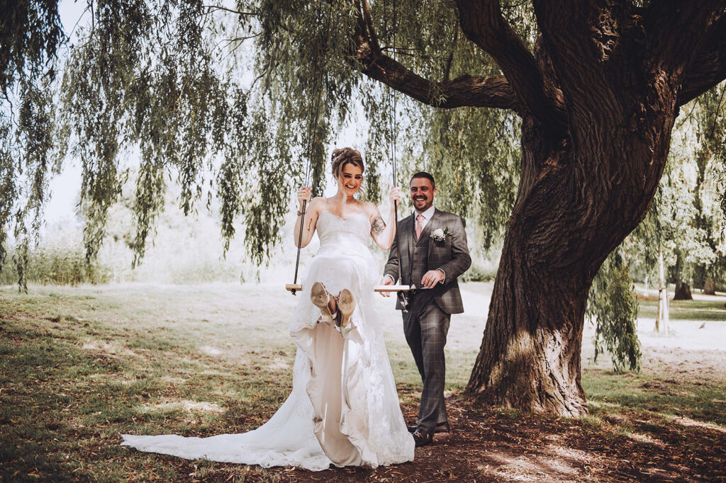 Bride and groom on swings at Ellington park in Thanet