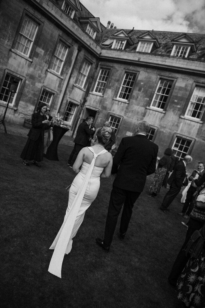 Bride and groom walking through luxury wedding venue on film