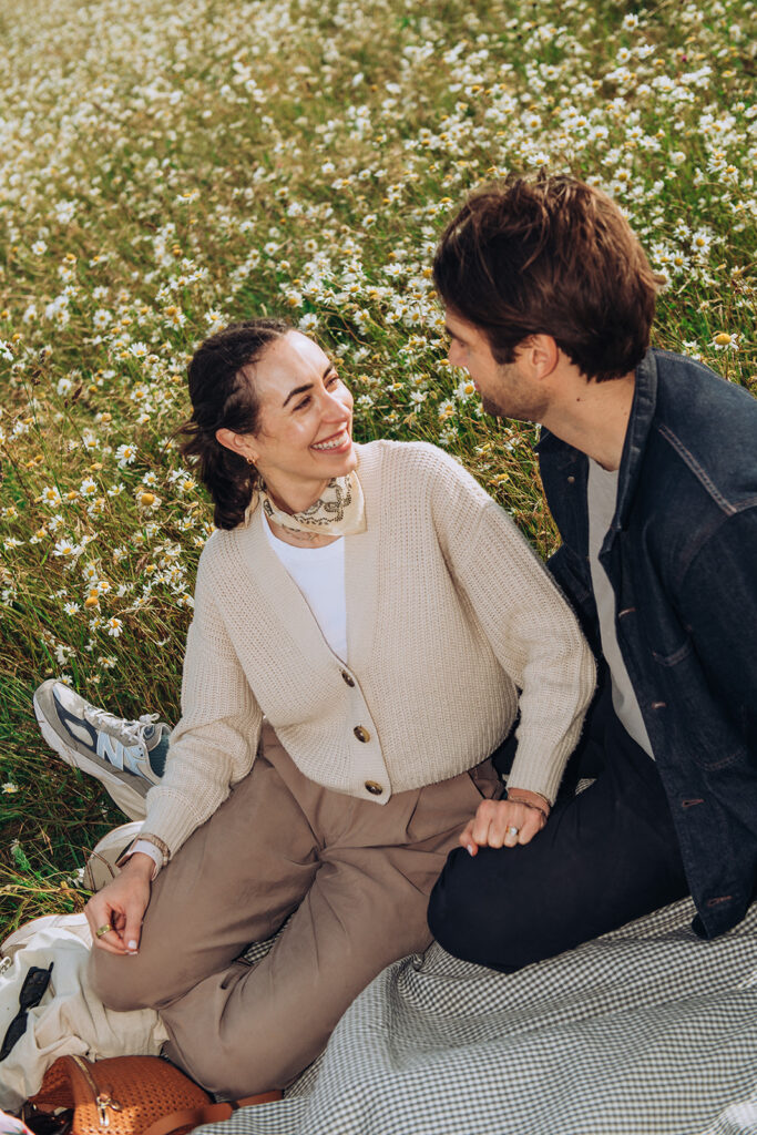 Newly engaged couple sat by Joss Bay fields