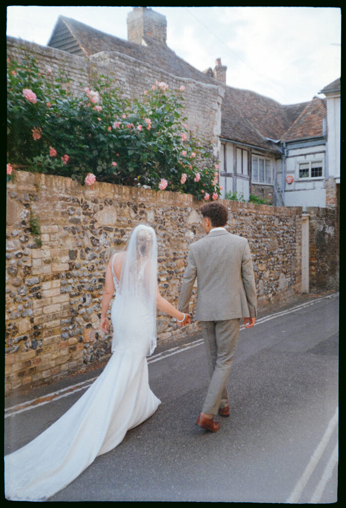 Bride and groom walking through Sandwich high street on analogue film