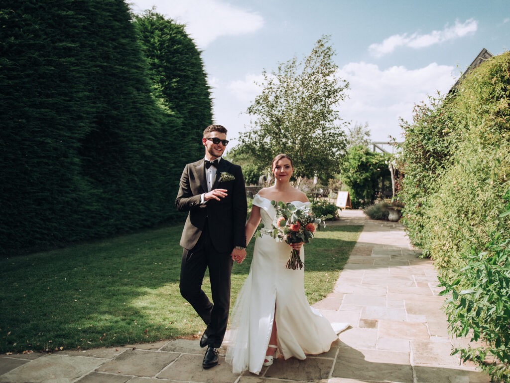 Bride and groom walking through South Farm garden