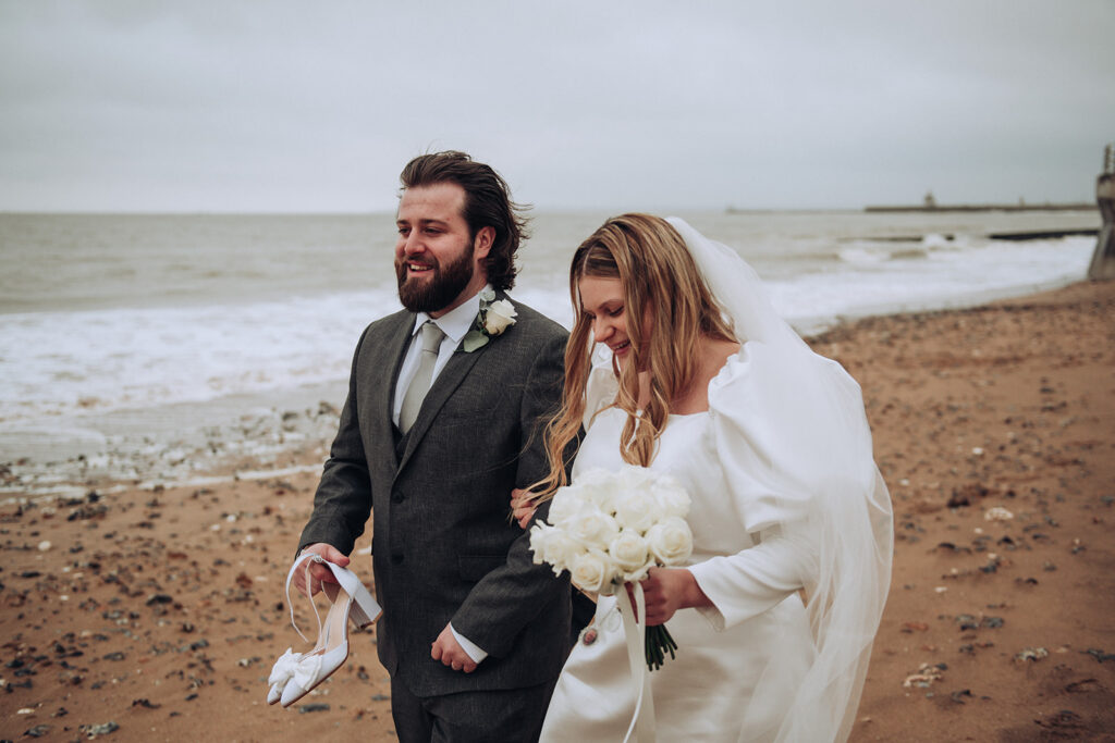 Bride and groom walking along Ramsgate East Cliff on their wedding