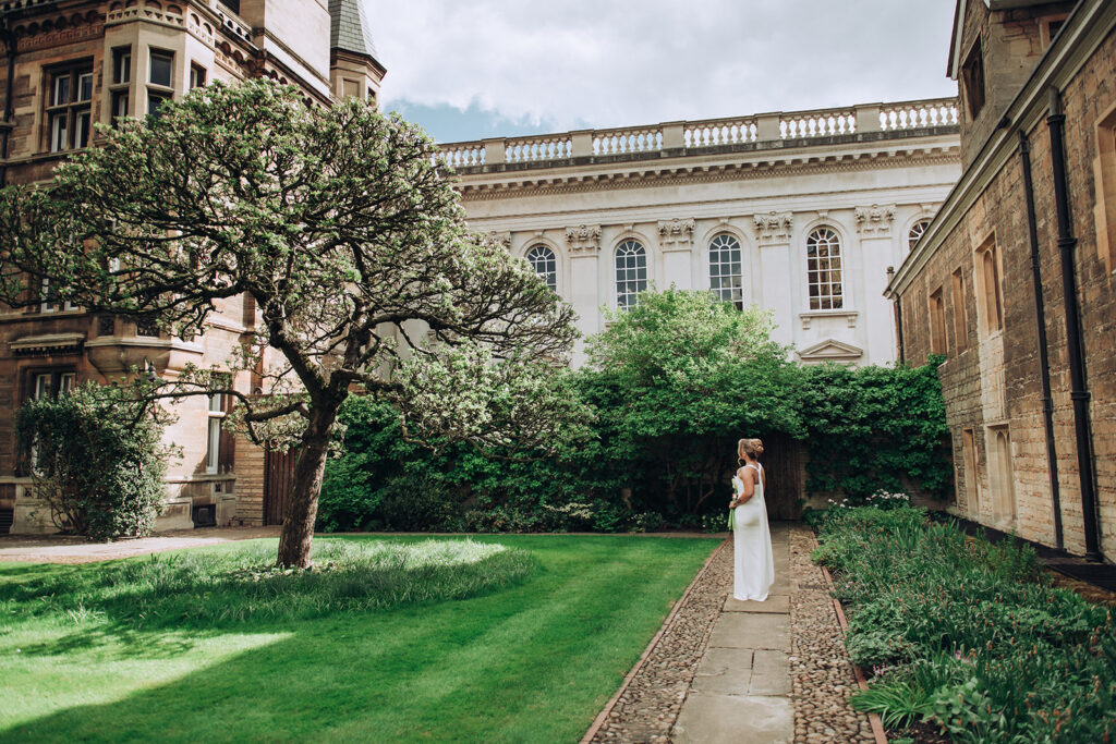 Bride stood in the garden at Gonville and Caius