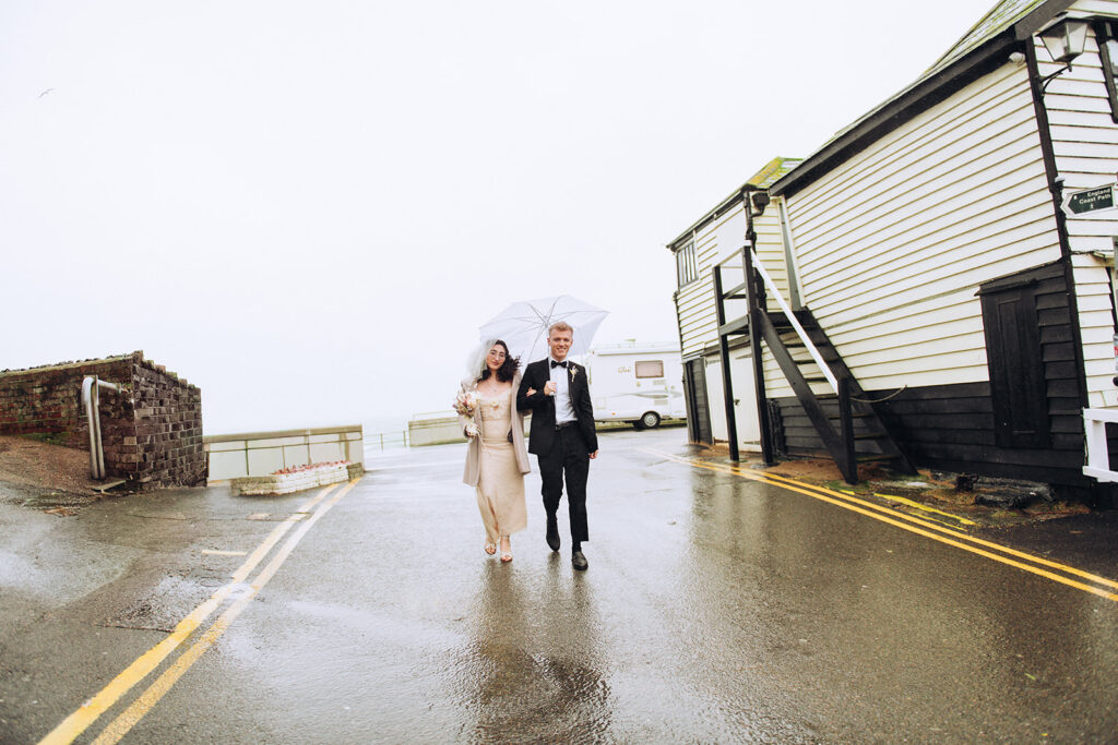 Bride and groom walking on the road through Viking Bay in Broadstairs