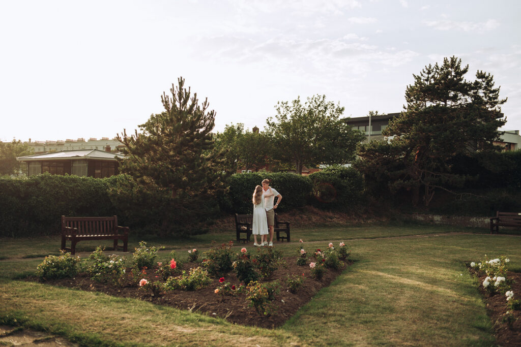 Bride and groom cuddling in West Cliff Rose Gardens