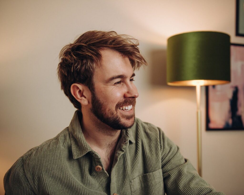 Portrait of Tom Keenan smiling in his studio space