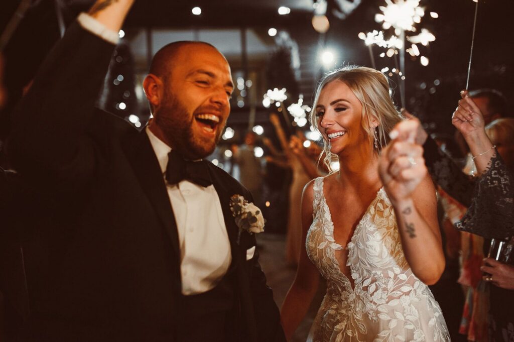 Bride and groom waving sparklers at their wedding at the Old Kent Barn
