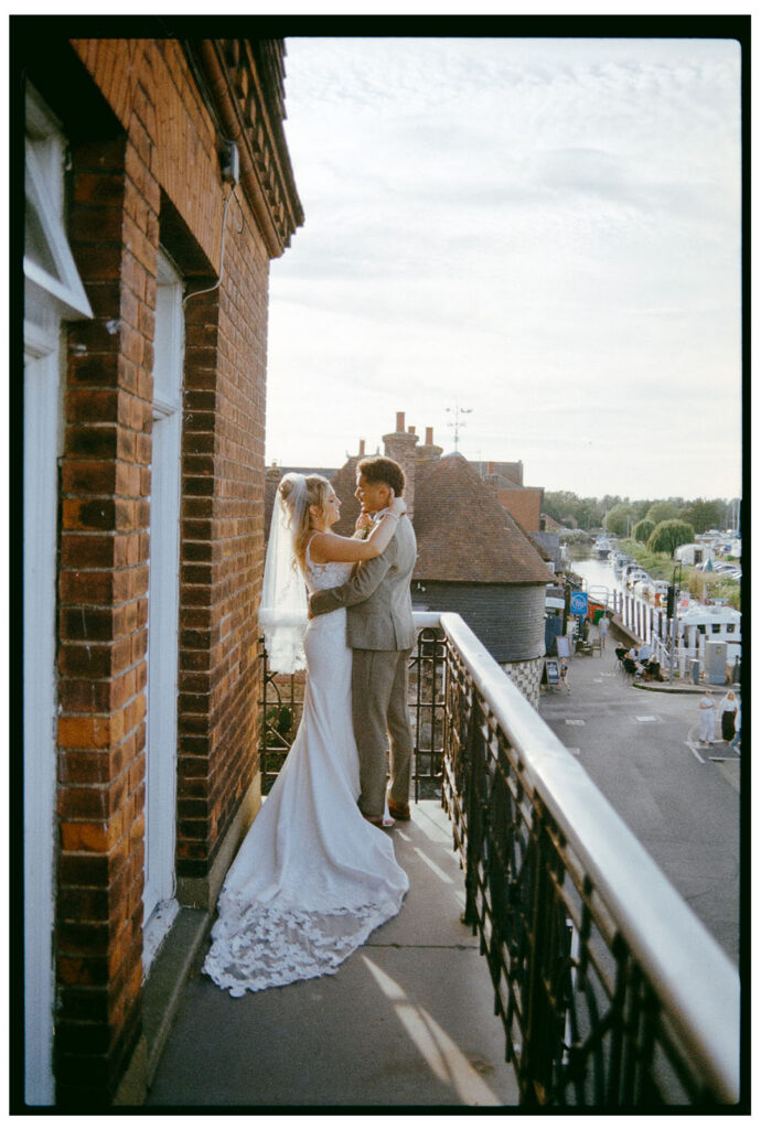 35mm film scan of bride and groom cuddling on balcony of the bell hotel