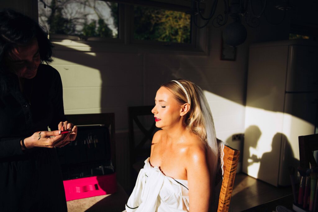 Bride having make up applied at wedding