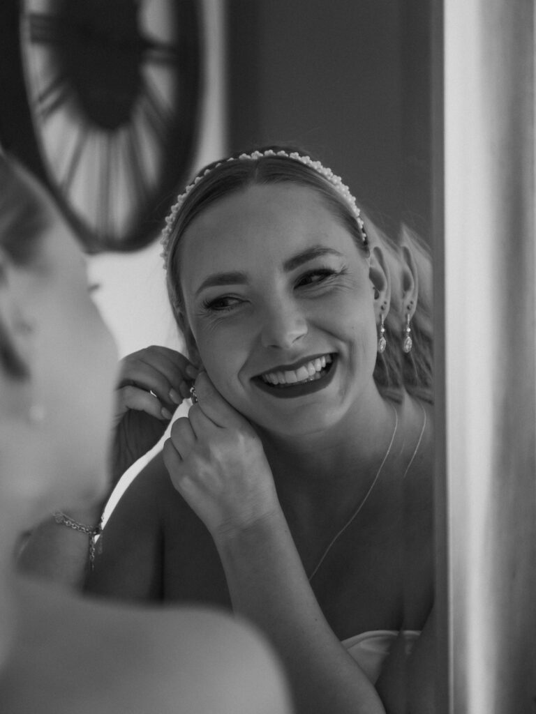 Bride putting on earrings at wedding