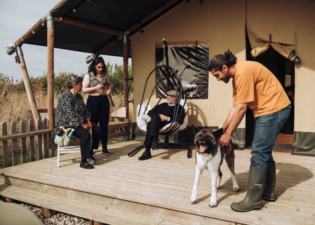 Family holding a dog at glamping site