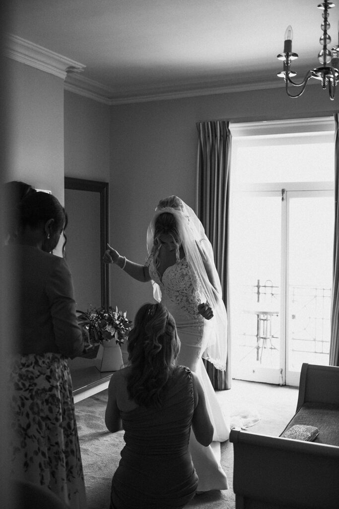 bride being assisted getting into dress