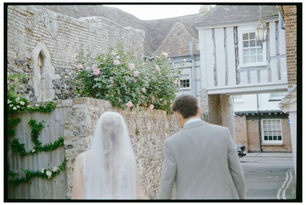 35mm film scan of bride and groom walking through Sandwich