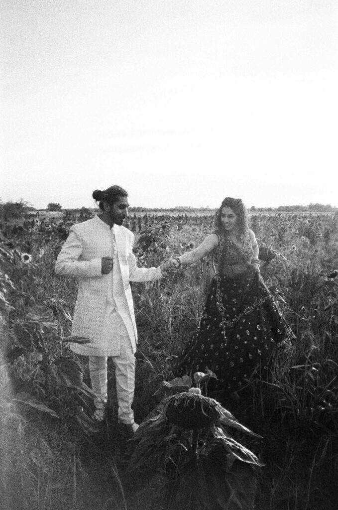Analogue film scan of couple walking through sunflower field