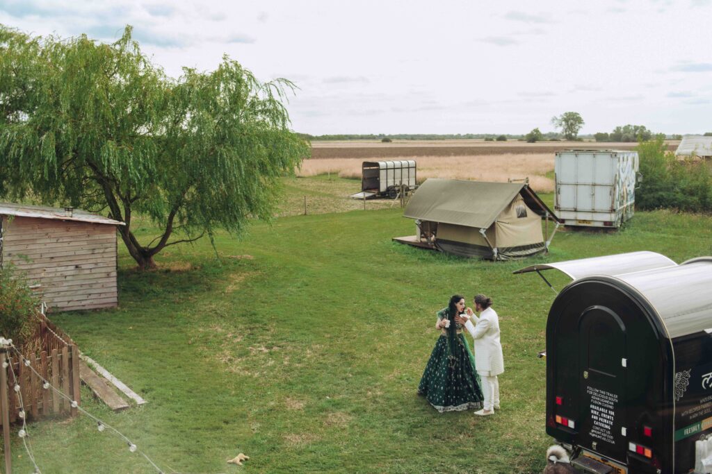 Bride and groom eating at wedding in field