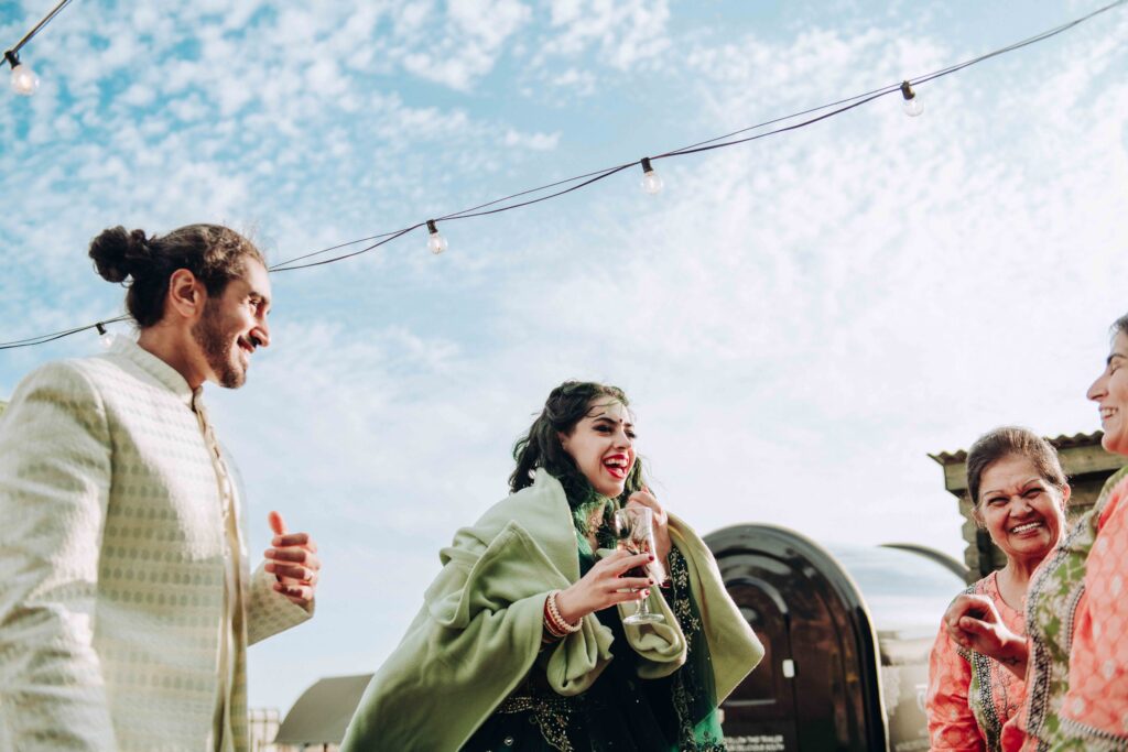 Bride and groom laughing with guests