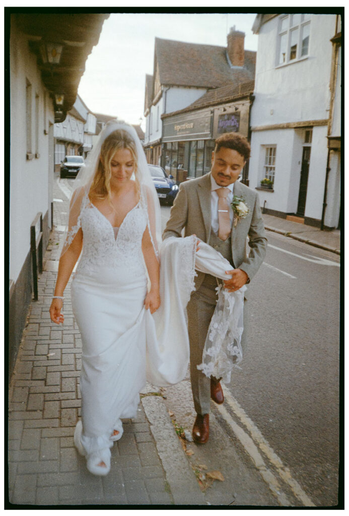 35mm film scan of bride and groom walking through Sandwich