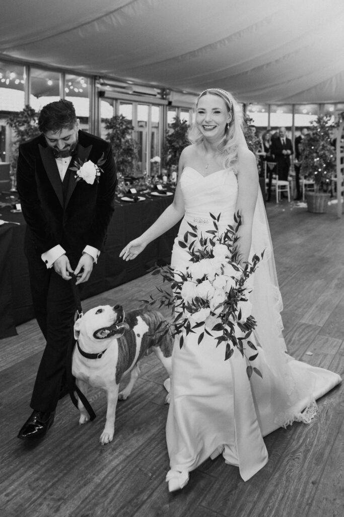 Bride and groom walking out of wedding with dog