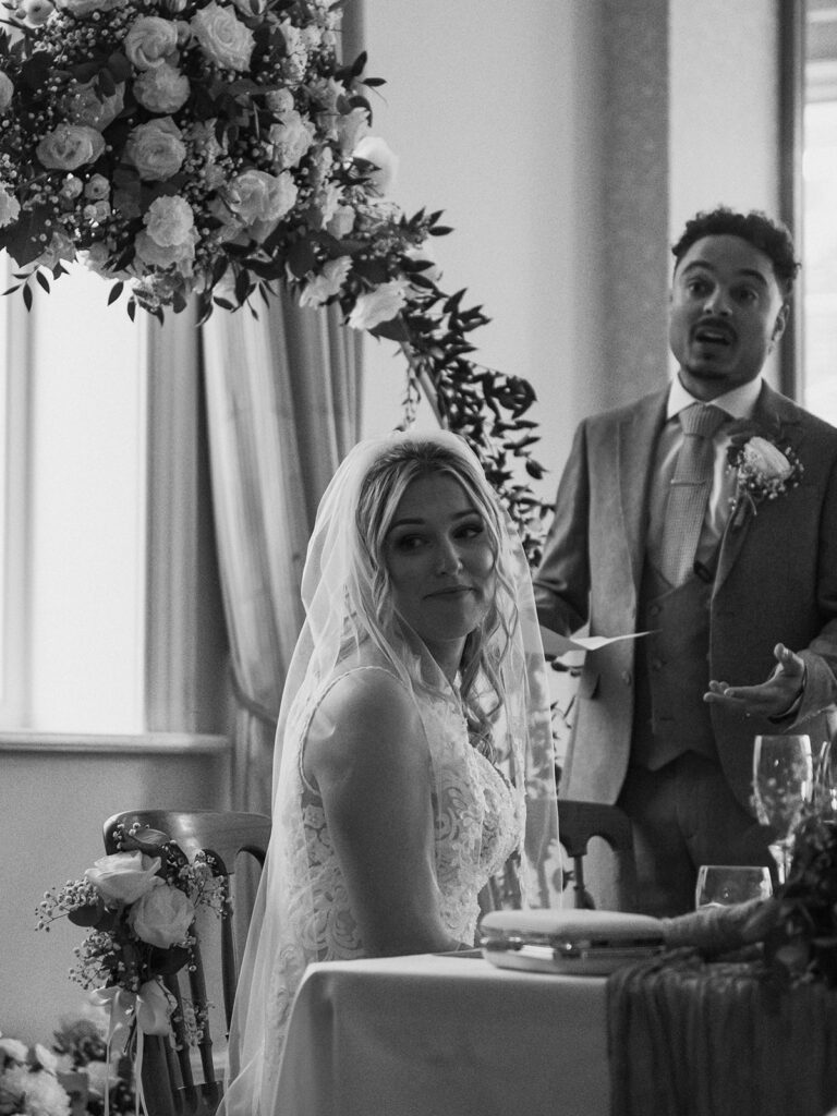 Groom giving speech and bride emotional during wedding