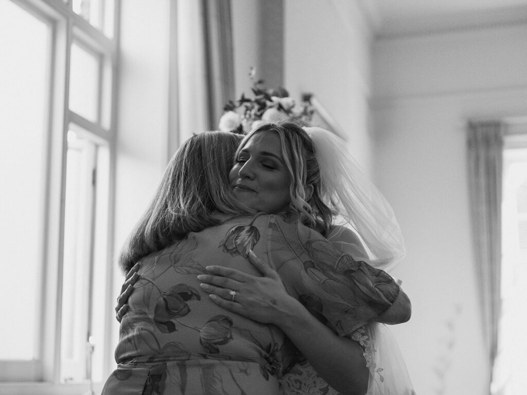 Bride hugging mother at wedding