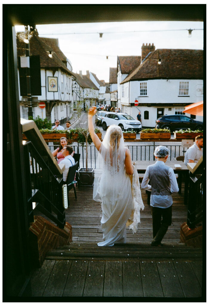 Analogue film photo of bride walking down steps at wedding