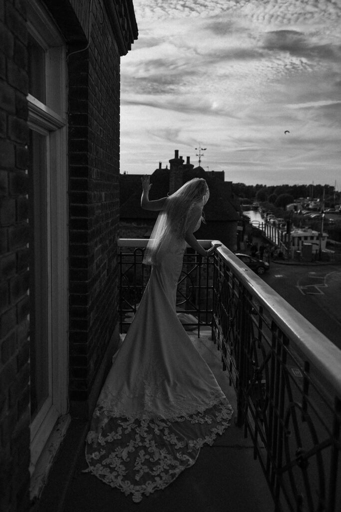 Bride waving on balcony at the bell hotel