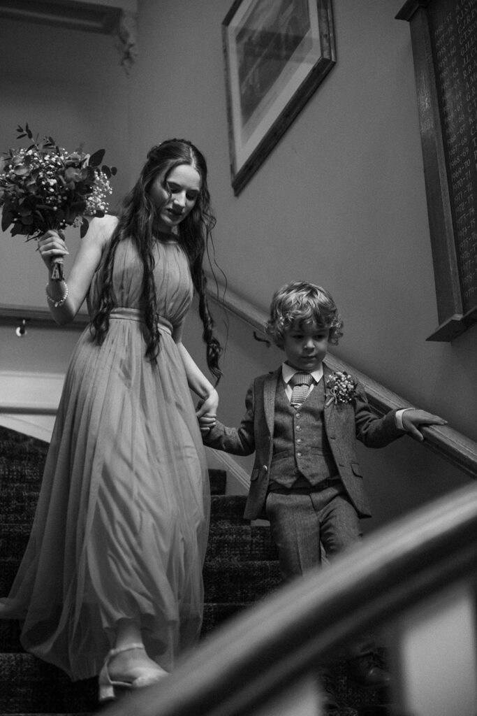 Bridesmaid and brother walking down stairs