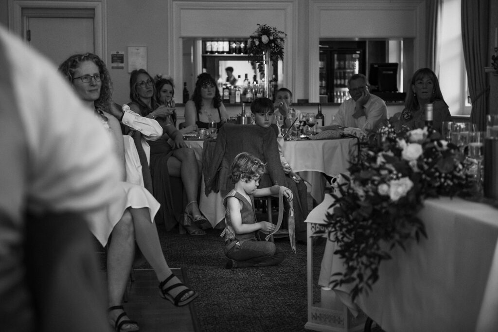 Child playing with tie at wedding