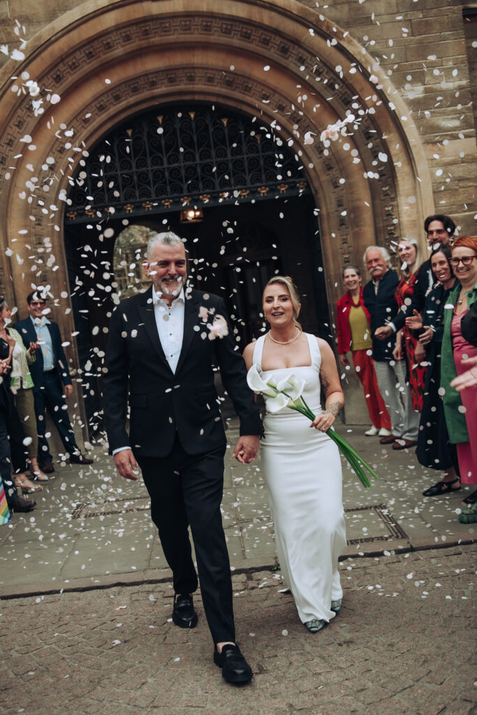 Bride and groom walking through confetti