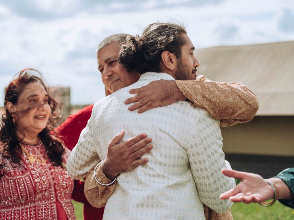 Groom hugging father