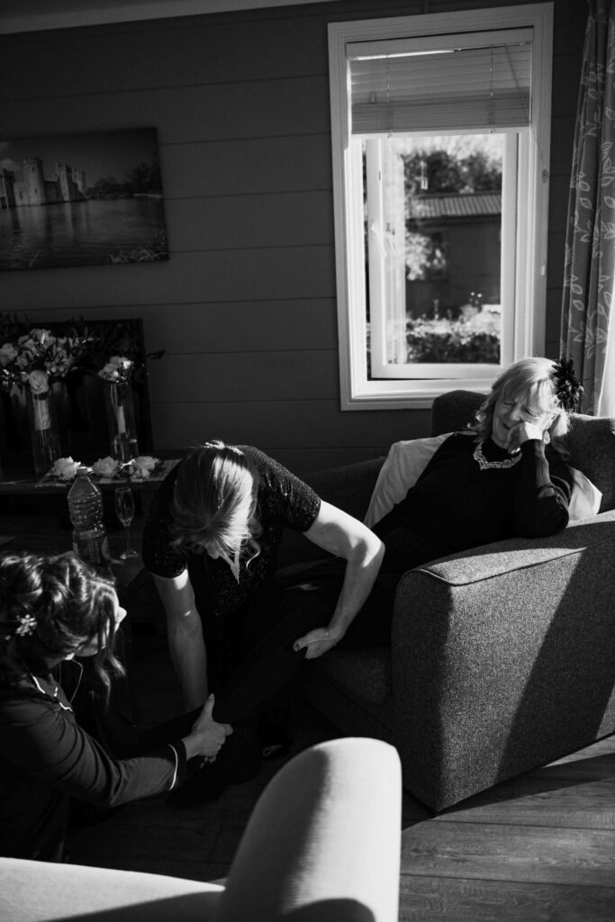 Wedding party helping put on shoes