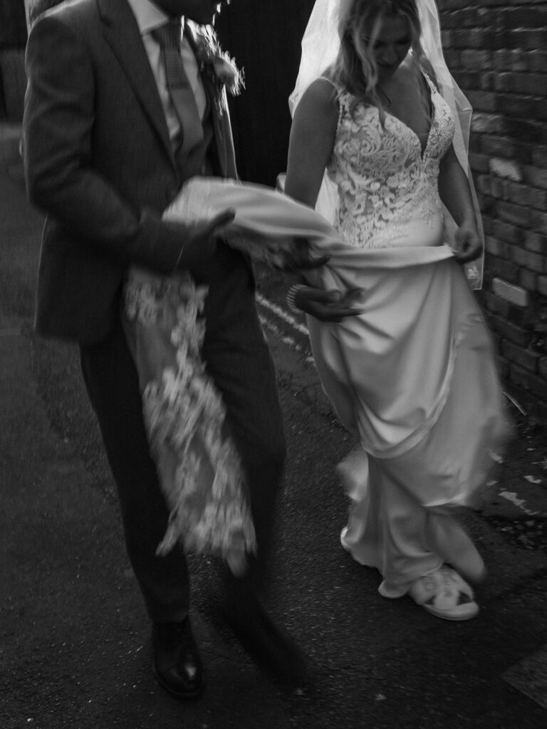 Editorial blurry photograph of bride and groom holding dress