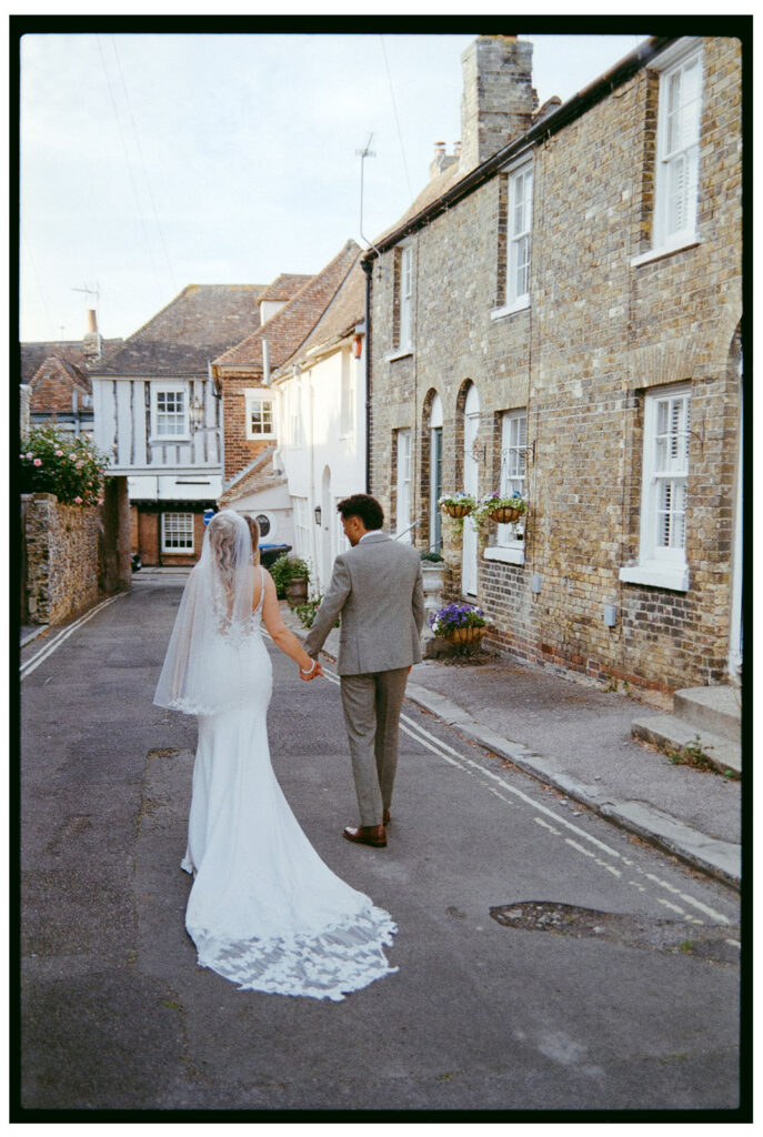 35mm film scan of bride and groom walking through Sandwich